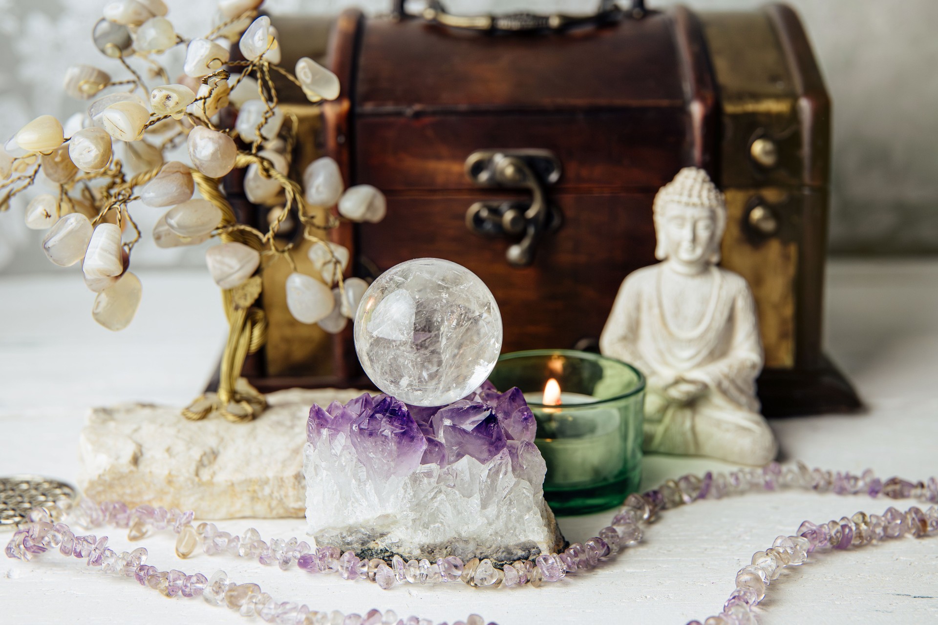 Gemstone crystal sphere or crystal balls known as crystallum orbis and orbuculum which is the beacon of peace and harmony in home environment. Natural clear quartz ball on amethyst geode in home.
